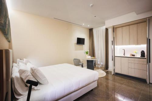 a hotel room with a white bed and a kitchen at Corral del Carbón GG Luxury Hotel Boutique in Granada