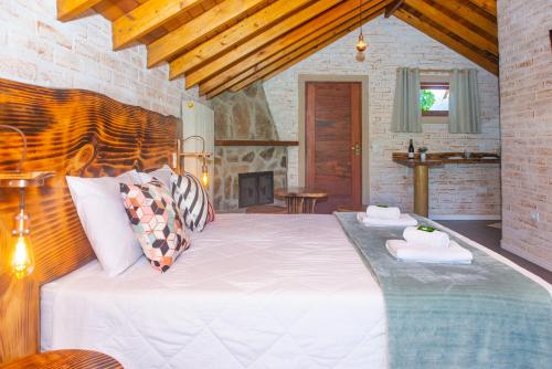 a bedroom with a large white bed in a room at Pousada Alpes da Mantiqueira in Monte Verde