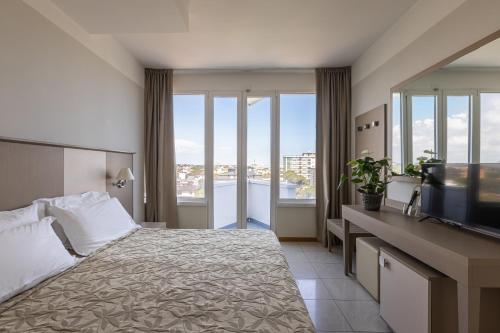 a hotel room with a bed and a television at Hotel Cristallo in Riccione