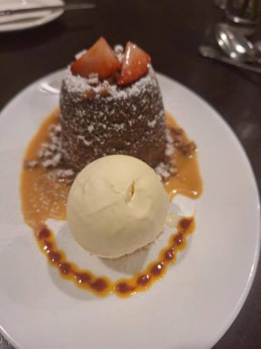 a piece of chocolate dessert with ice cream on a plate at Carrygerry Country House in Shannon