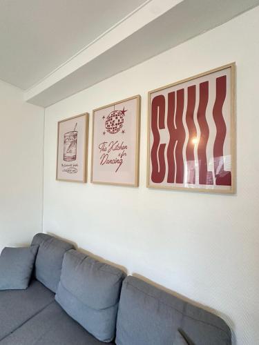 3 photos sur un mur au-dessus d'un canapé bleu dans l'établissement Las Vegas - appartement à Reims, à Reims