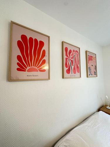 trois images encadrées sur un mur au-dessus d'un lit dans l'établissement Las Vegas - appartement à Reims, à Reims