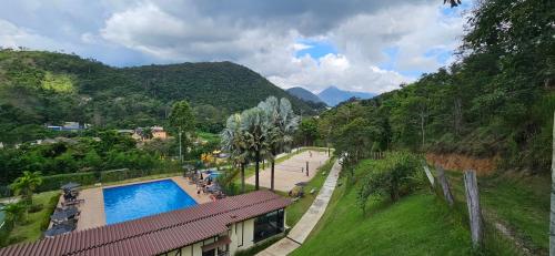 a view of a resort with a swimming pool and mountains at Imperial Studio - Itaipava - Granja Brasil Resort in Petrópolis