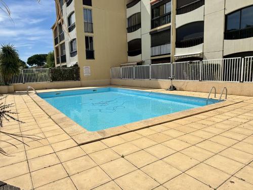 - une piscine en face d'un immeuble dans l'établissement Studio cabine 4 couchages ARGELES SUR MER AR030-059, à Argelès-sur-Mer