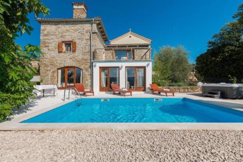 a villa with a swimming pool in front of a house at Villa Sussini in Central Istria for 8 people with jacuzzi & pet friendly in Krbune