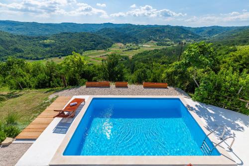 a swimming pool with a view of the mountains at Villa Sussini in Central Istria for 8 people with jacuzzi & pet friendly in Krbune