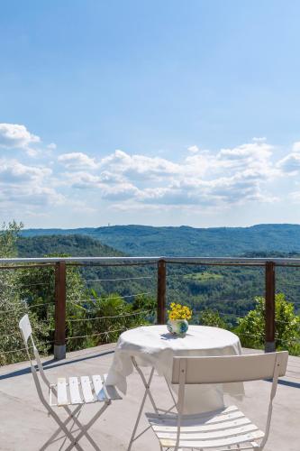 a table and chairs on a balcony with a view at Villa Sussini in Central Istria for 8 people with jacuzzi & pet friendly in Krbune
