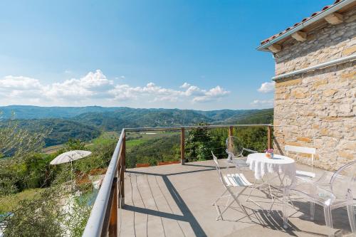 a patio with a table and chairs on a balcony at Villa Sussini in Central Istria for 8 people with jacuzzi & pet friendly in Krbune
