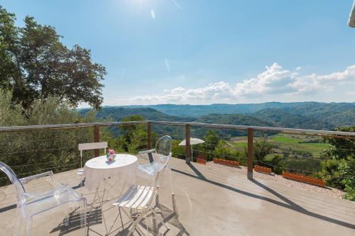 a balcony with chairs and a table with a view at Villa Sussini in Central Istria for 8 people with jacuzzi & pet friendly in Krbune