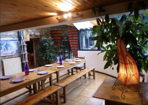 - une longue table en bois dans une pièce avec une plante dans l'établissement EQUI-Libre, à Porta