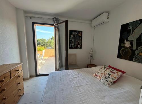 une chambre avec un lit et une porte coulissante en verre dans l'établissement Appartement Hauts de Vaugrenier, à Villeneuve-Loubet