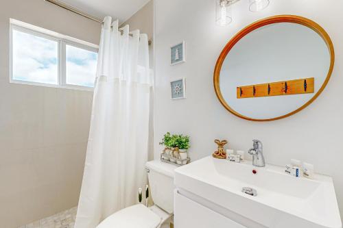 a white bathroom with a sink and a mirror at Seabreeze Haven in Marathon