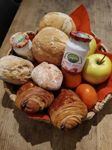 a basket filled with different types of bread and fruit at Au loupus in Durbuy