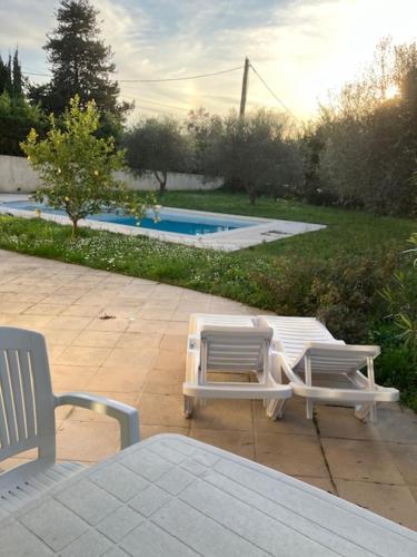 - deux chaises et une table à côté de la piscine dans l'établissement Jas ALEXANDRE, à Saint-Paul-de-Vence