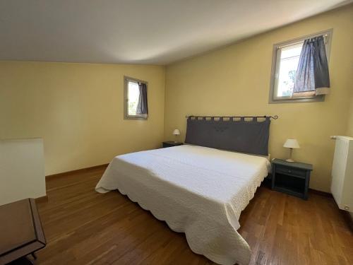 - une chambre avec un lit blanc et 2 fenêtres dans l'établissement Jas ALEXANDRE, à Saint-Paul-de-Vence