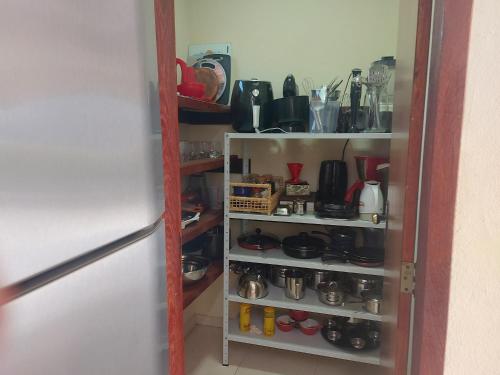 a kitchen pantry with a shelf full of utensils at Temporada no Paraíso em Teresópolis in Teresópolis