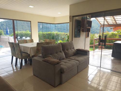 a living room with a couch and a table at Temporada no Paraíso em Teresópolis in Teresópolis