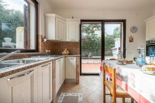 a kitchen with white cabinets and a table and a window at Villa La Fata in Cuile Pazzoni
