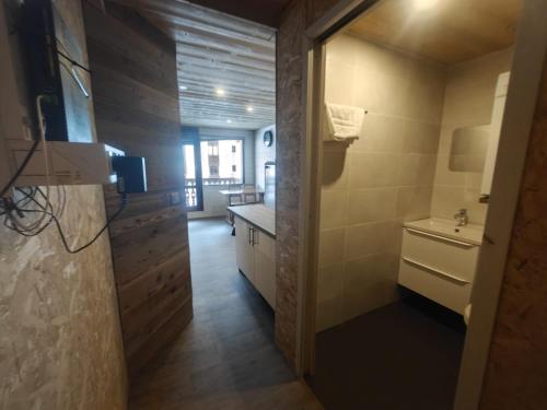 a kitchen with a door leading into a bathroom at MyHome - Rénové en 2024 ! Hameau Borsat 3 15 - studio 2 cabines 4 pax sur les pistes in Tignes