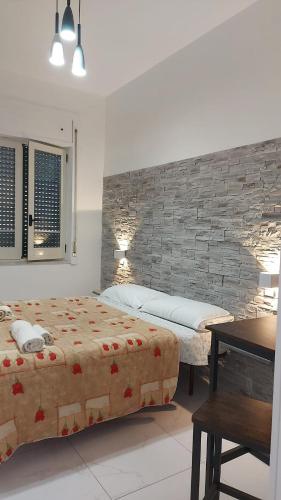 a bedroom with a bed and a brick wall at Vitiello Maria's home in Pompei