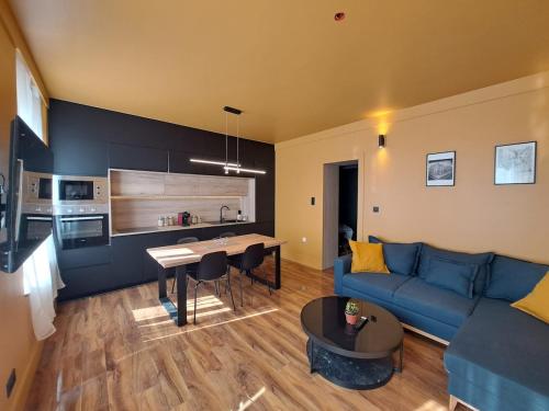 un salon avec un canapé bleu et une table dans l'établissement GENÈVE - Appartement Fastueux, à Reims