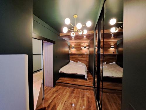 Cette chambre comprend deux lits et un lustre. dans l'établissement GENÈVE - Appartement Fastueux, à Reims