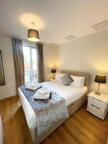 una camera da letto con un letto con due asciugamani sopra di Blue Sky Apartments@Guildford Town Centre a Guildford