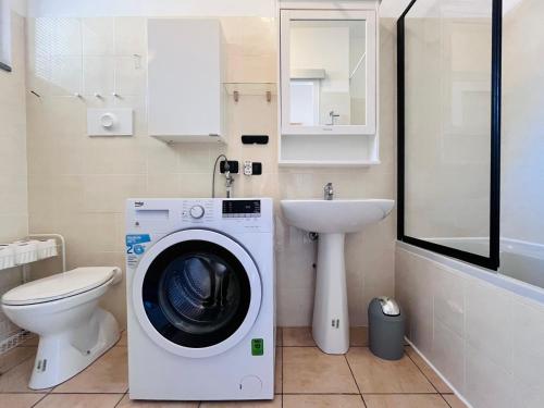 a bathroom with a washing machine and a sink at Vespa Azzurra Apartments Free Parking in Acquaseria