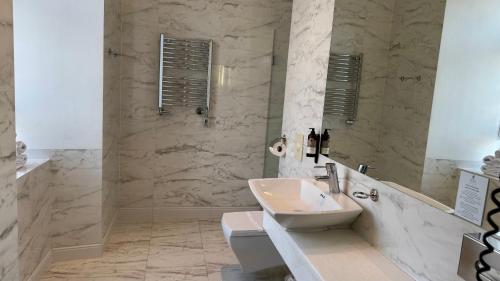 a white bathroom with a sink and a mirror at Hotel Krasicki in Lidzbark Warmiński