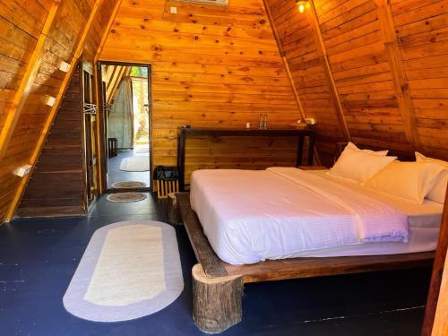 a bedroom with a bed in a wooden cabin at Luma in Palolem