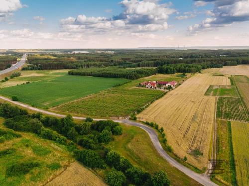 an aerial view of a farm with a field and road at Winnica Mozów in Mozów