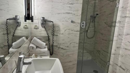 a bathroom with a shower and a sink and a toilet at Hotel Krasicki in Lidzbark Warmiński