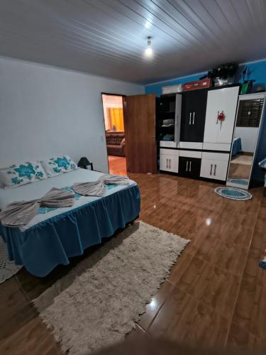 a bedroom with a bed with a blue bedspread at Rancho Pé da Pedra in São Bento do Sapucaí