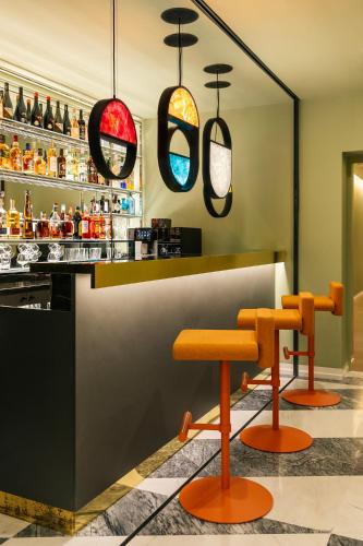 a bar with orange stools and pendant lights at Moselle Armenia Wellness & Medical SPA Jermuk in Jermuk
