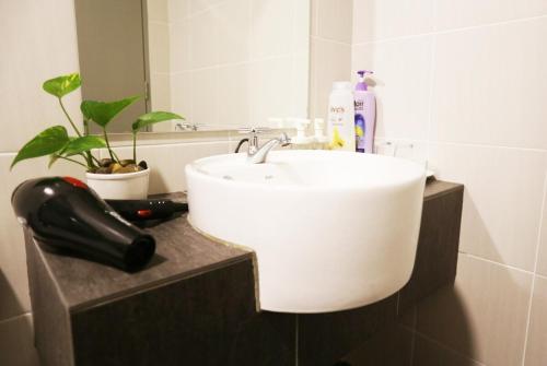 a bathroom with a white sink and a mirror at EVO SOHO Bangi in Kampong Sungai Ramal Dalam
