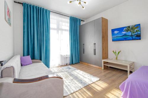 a bedroom with a bed and a window with blue curtains at Красотка на Нурлы Жол in Astana