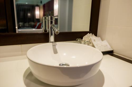 a white sink in a bathroom with a mirror at Nak Nakara Hotel in Chiang Rai