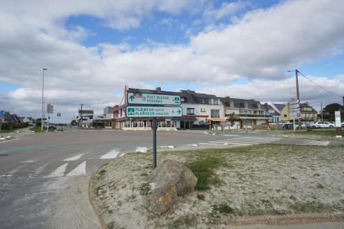 a street sign in the middle of a parking lot at Evasion - 100m de la mer - parking in Ploemeur