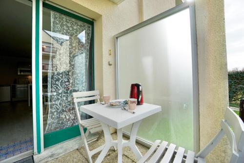 a white table and chairs on a balcony at Evasion - 100m de la mer - parking in Ploemeur
