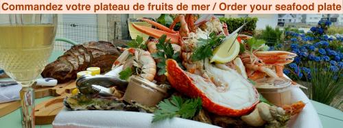 a plate of seafood on a table with a glass of wine at Evasion - 100m de la mer - parking in Ploemeur