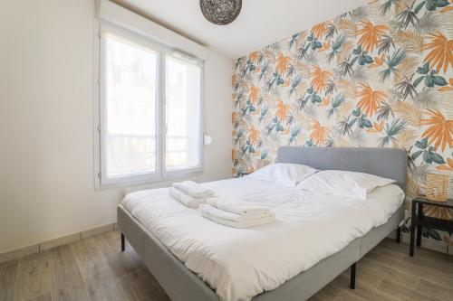 une chambre avec un lit avec des serviettes dessus dans l'établissement Cosy en centre ville, à Amiens