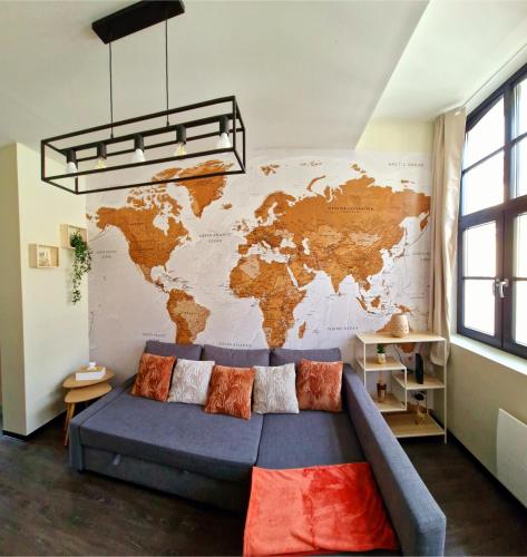 a couch in a room with a map on the wall at Globe-Rêveur, vue Beffroi & WiFi, Hypercentre in Douai