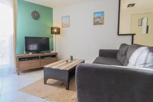 un salon avec un canapé et une table basse dans l'établissement Cosy en centre ville, à Amiens