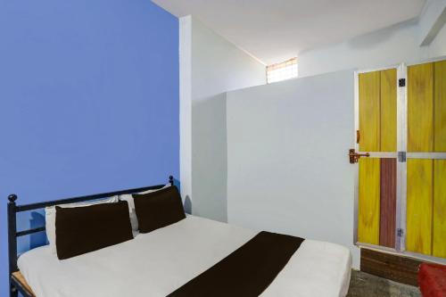 a bedroom with a bed and a wooden door at SPOT ON 7 Day Stay in Chandrapur