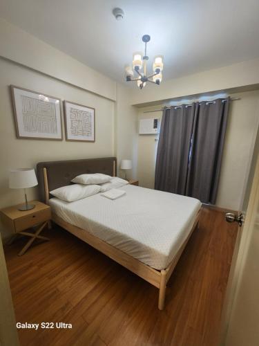 a bedroom with a bed and a chandelier at 2BR NORTHPOINT CONDO Free Airport Pick up for 3 nights stay or more in Davao City