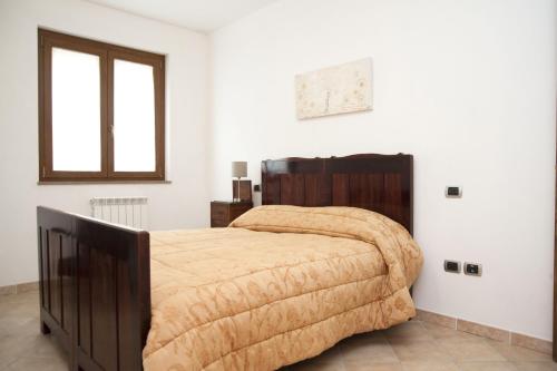 a bedroom with a large bed with a wooden headboard at CasArmando Casa Vacanze in Foligno