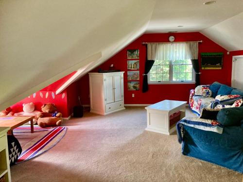 a living room with red walls and a couch at Bellport Village Gem in Bellport