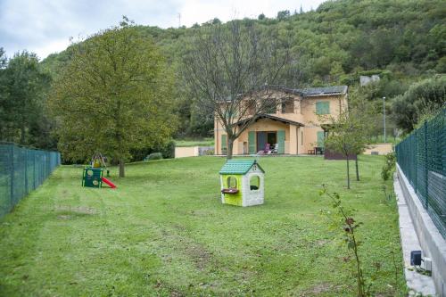 a yard with a dog house and a playground at CasArmando Casa Vacanze in Foligno