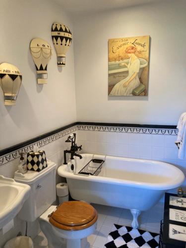 a bathroom with a tub and a toilet and a sink at Bellport Village Gem in Bellport
