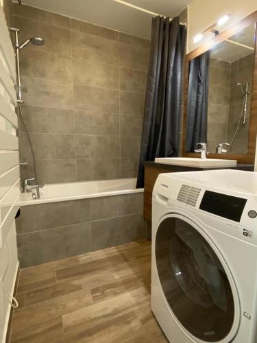 La salle de bains est pourvue d'une baignoire et d'un lave-linge. dans l'établissement Foux d Allos Centre de la Station 4 Pièces 8 Personnes, à Allos